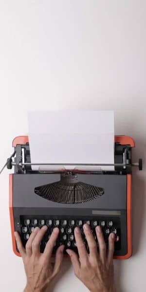 Becoming a writer - typewriter with hands on keys
